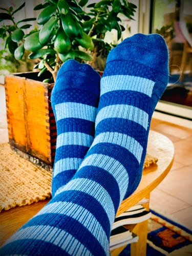 Customer's feet wearing blue Diasocks stödstrumpor while resting on a table.
